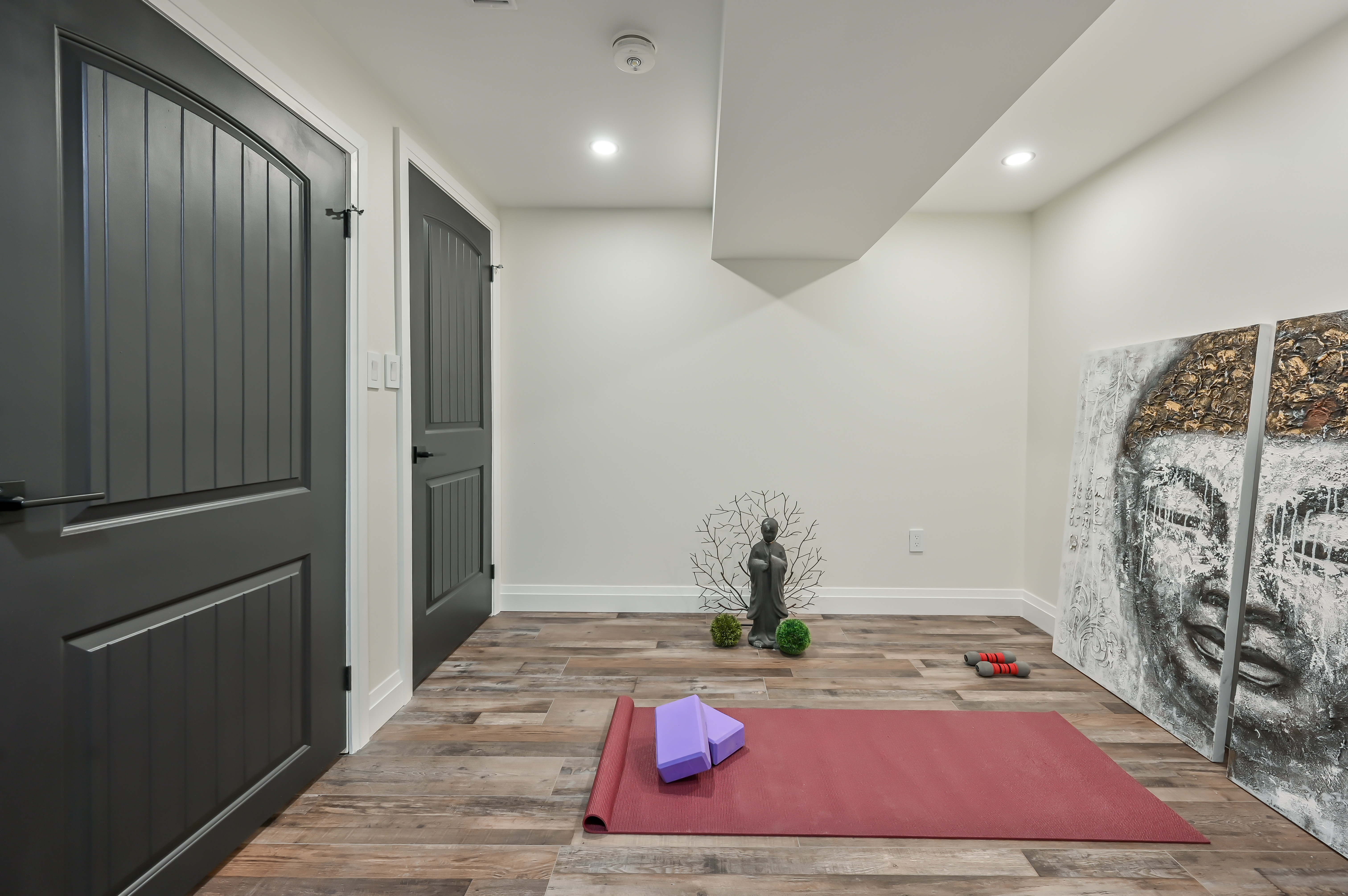 Clean finished basement with quality flooring and trim work — excellent wide-angle portfolio shot showing transformation potential — Kron, Hamilton | MTC Renovations